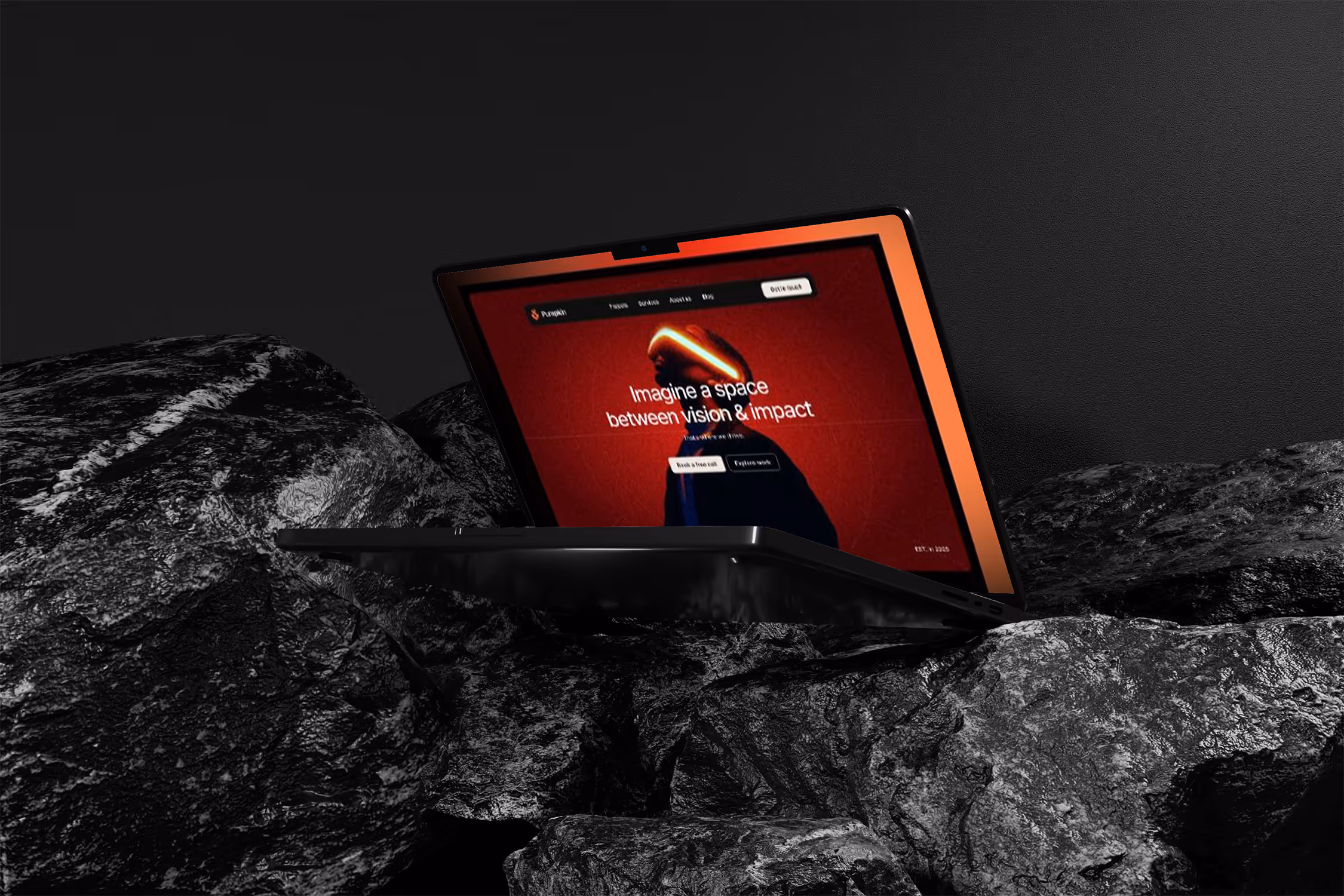 Laptop pe fundal stancos afisand un design web modern cu accente rosii