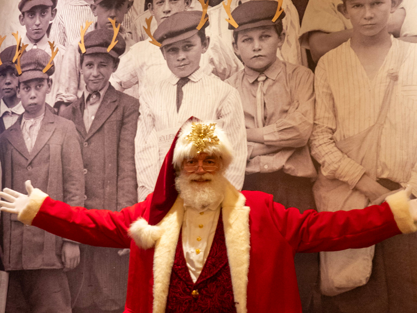 Santa Claus in front of mural or newsboys