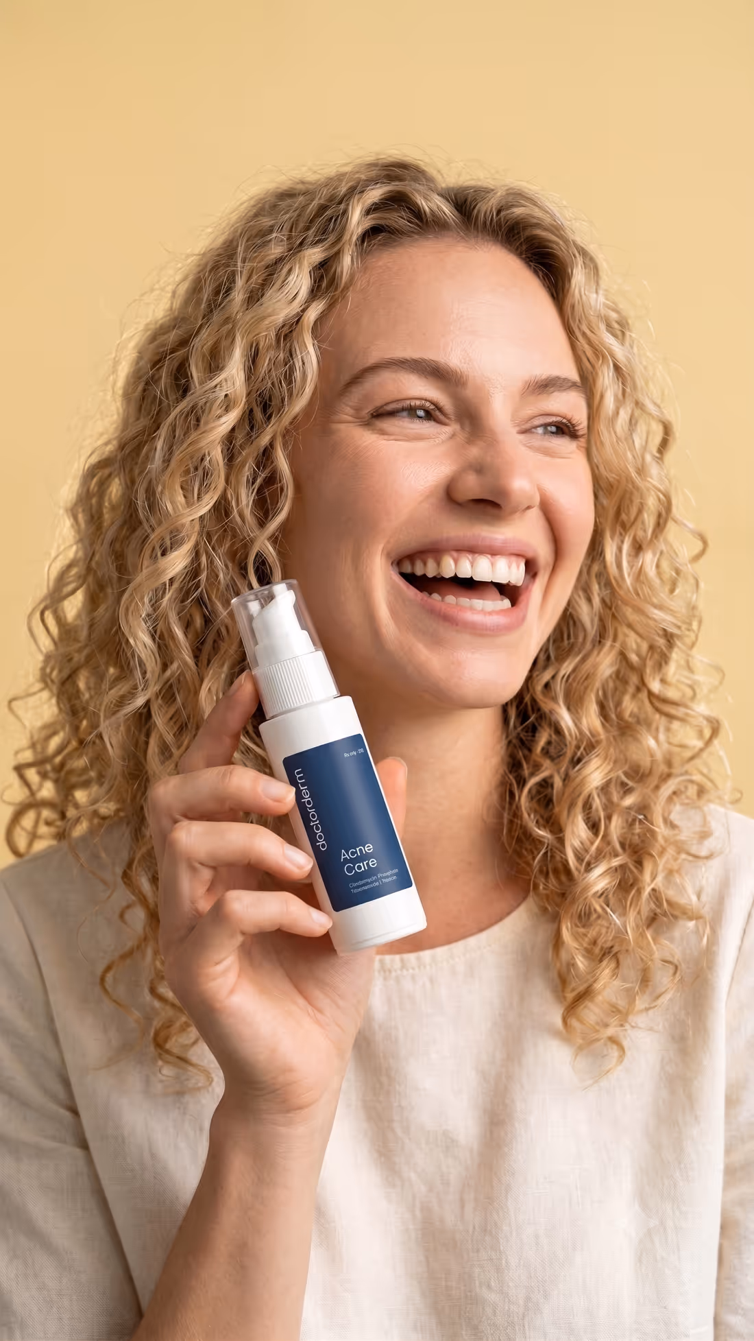 A customer smiling, holding DoctorDerm Acne Care