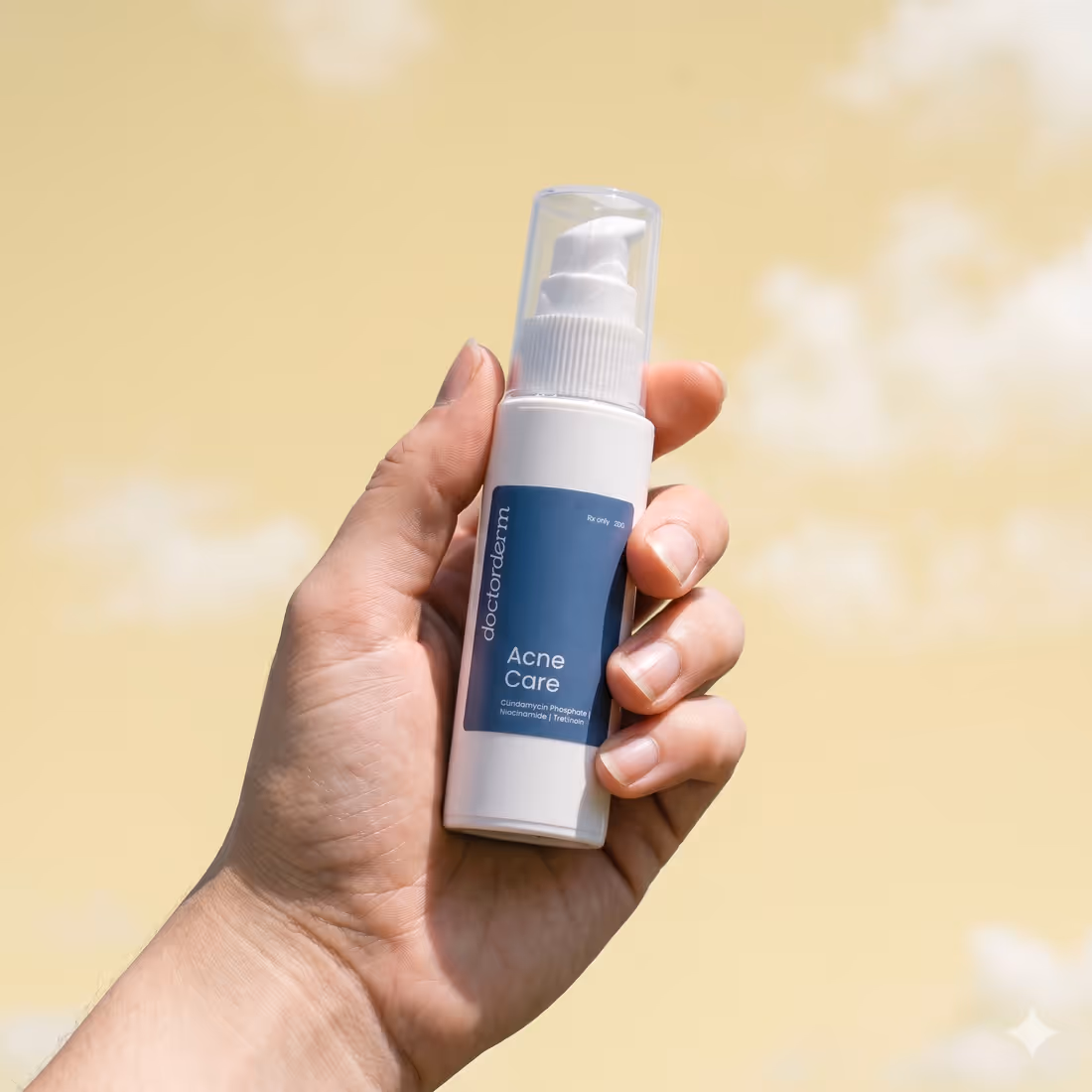 A hand holding DoctorDerm Acne Care against a yellow sky