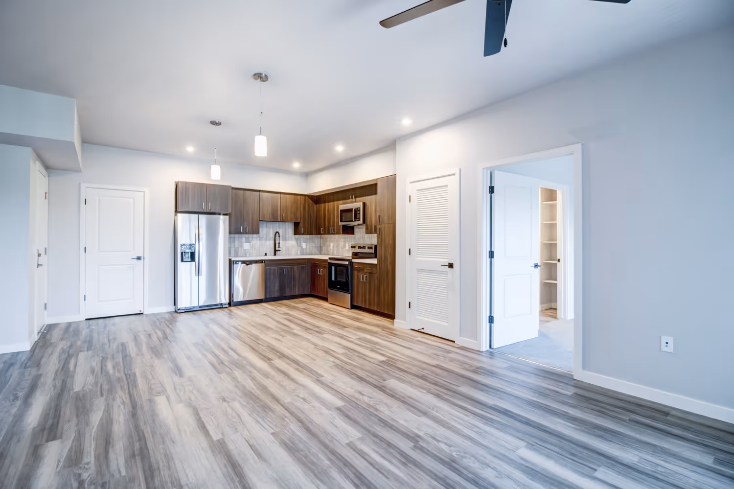 Kitchen with brown cabinets and living room with vinyl flooring