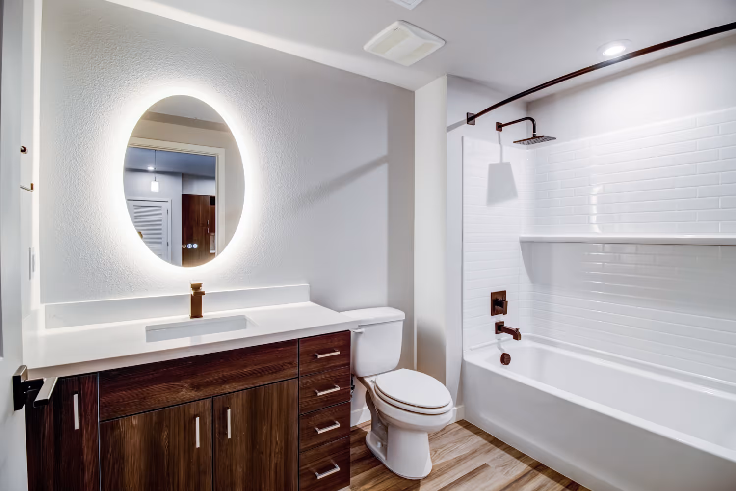 Bathroom with light up mirror and brown cabinets