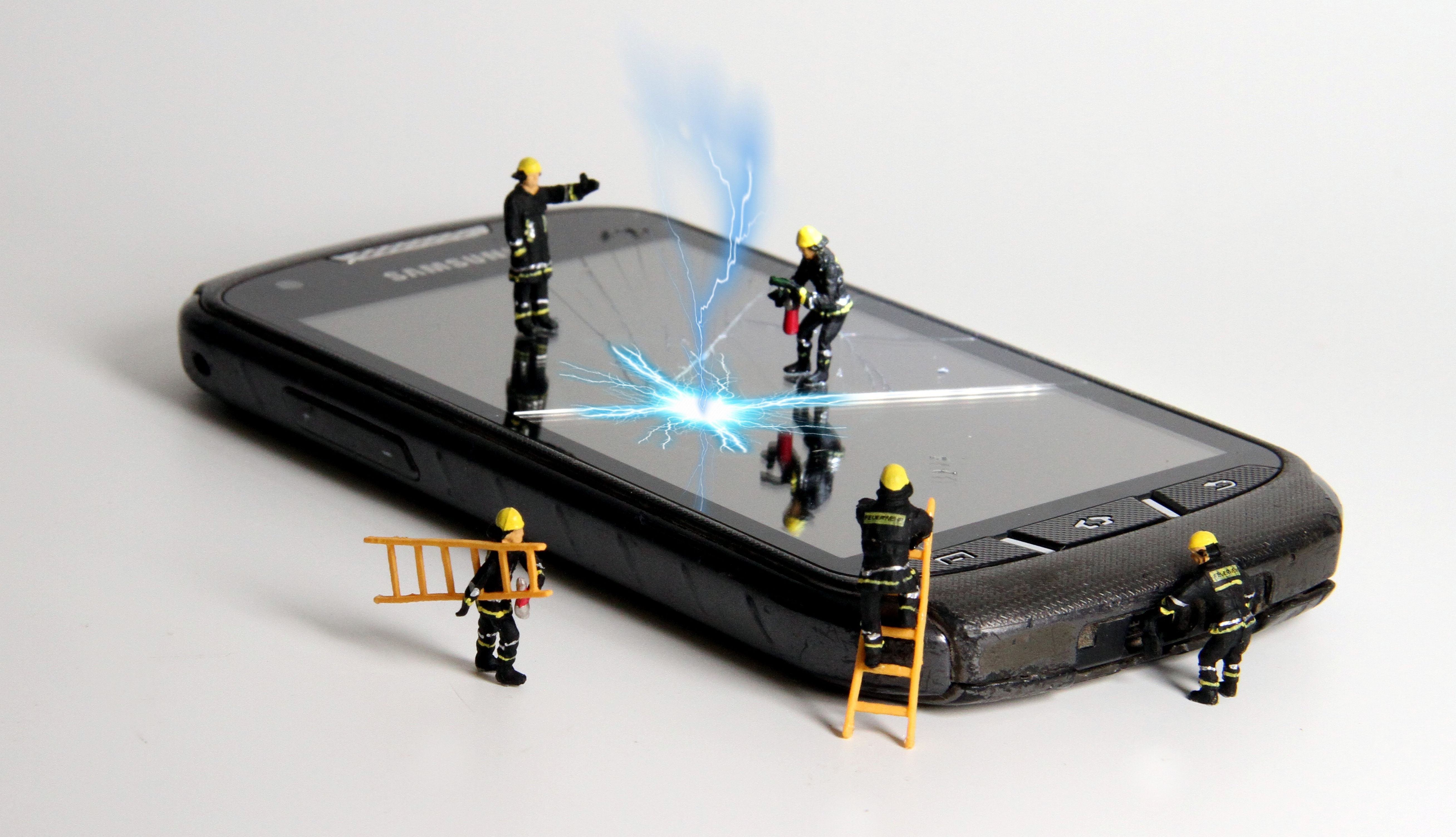 Cracked smartphone screen with shattered glass being worked on