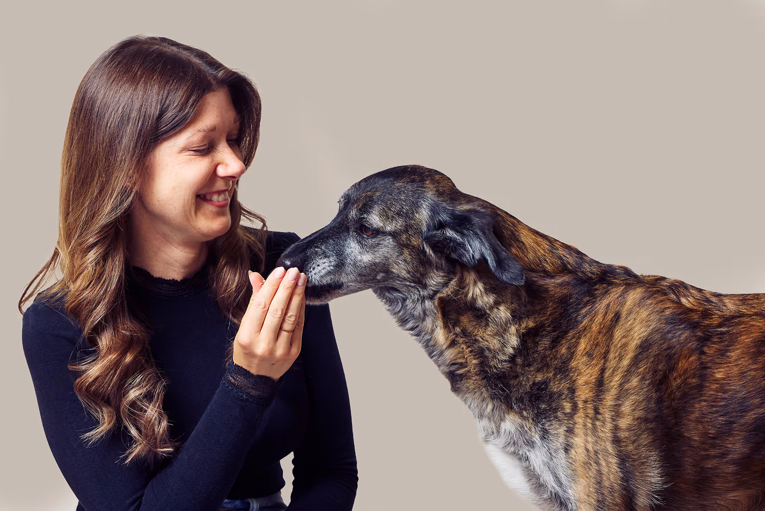 Anna belohnt ihre Hündin Zola mit einem Leckerli aus der flachen Hand