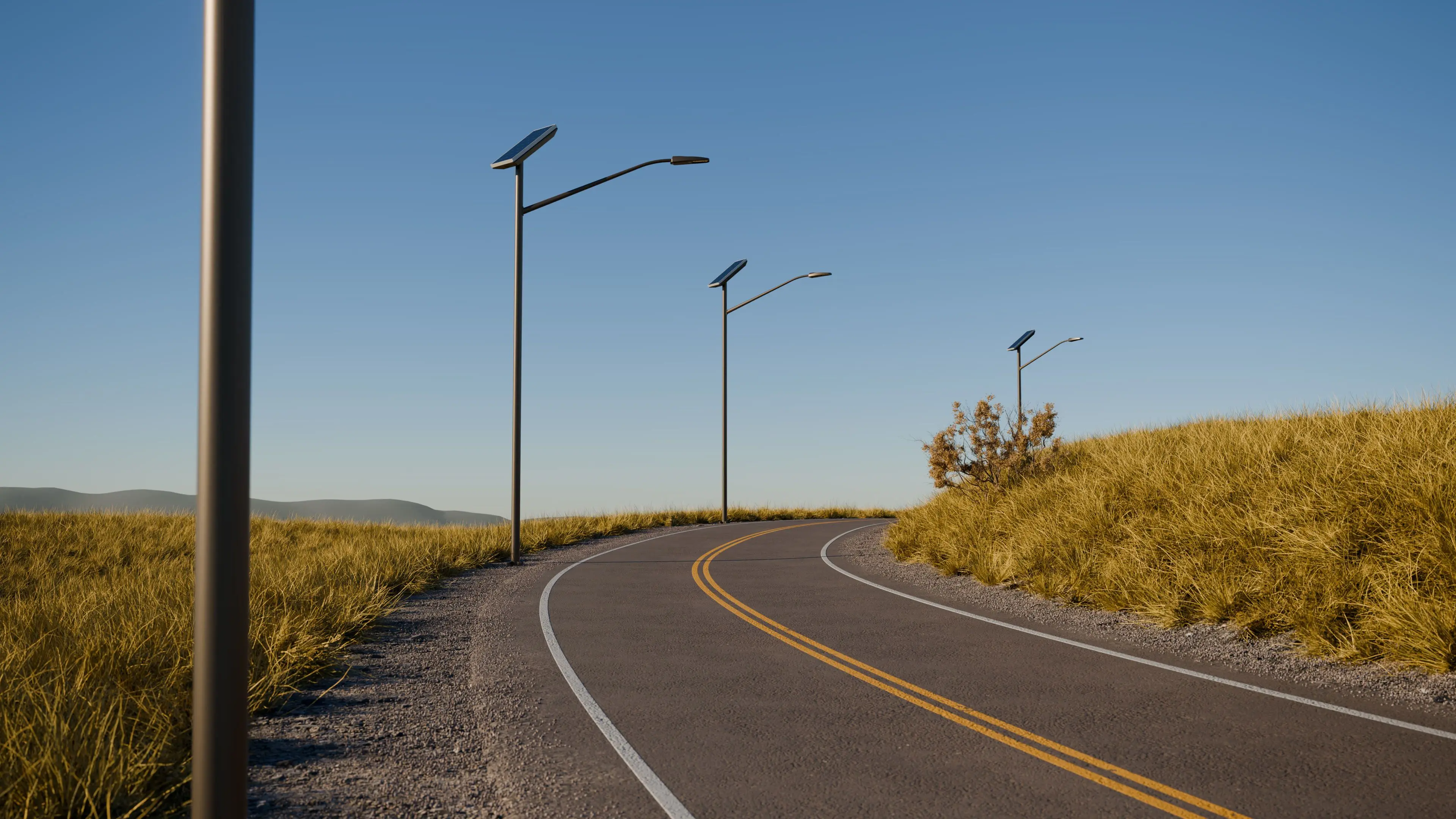 Curved paved road lined with solar-powered streetlights and dry grass under a clear blue sky.