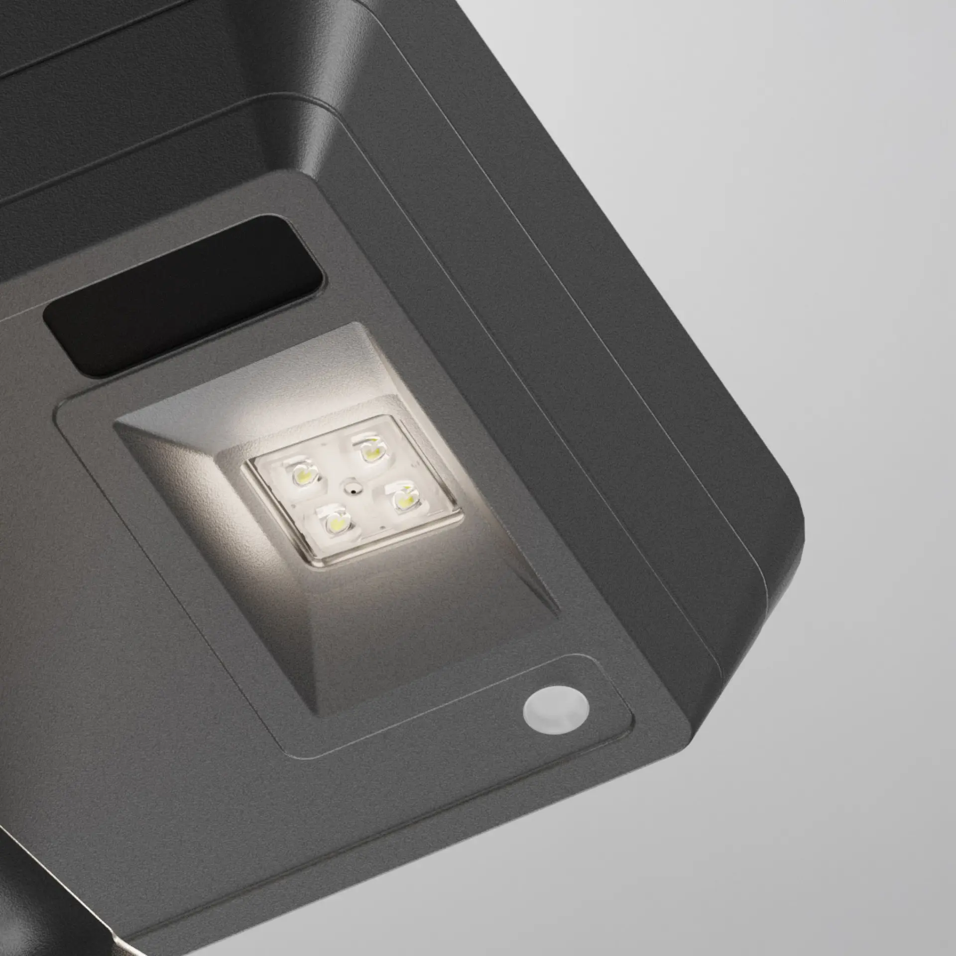 Close-up of a modern outdoor LED floodlight with four illuminated bulbs in a recessed fixture.