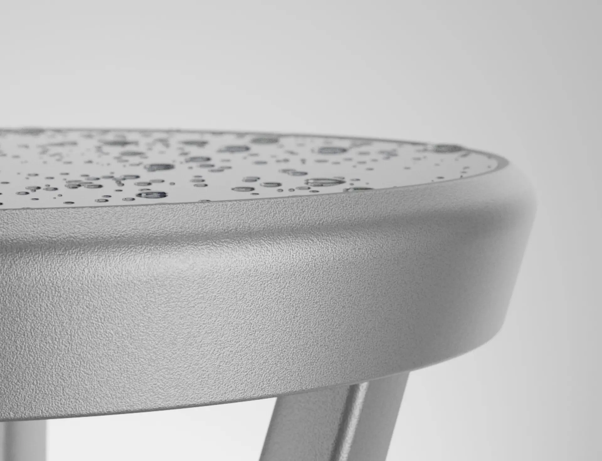 Close-up of grey textured round bollard edge with water droplets on the surface.