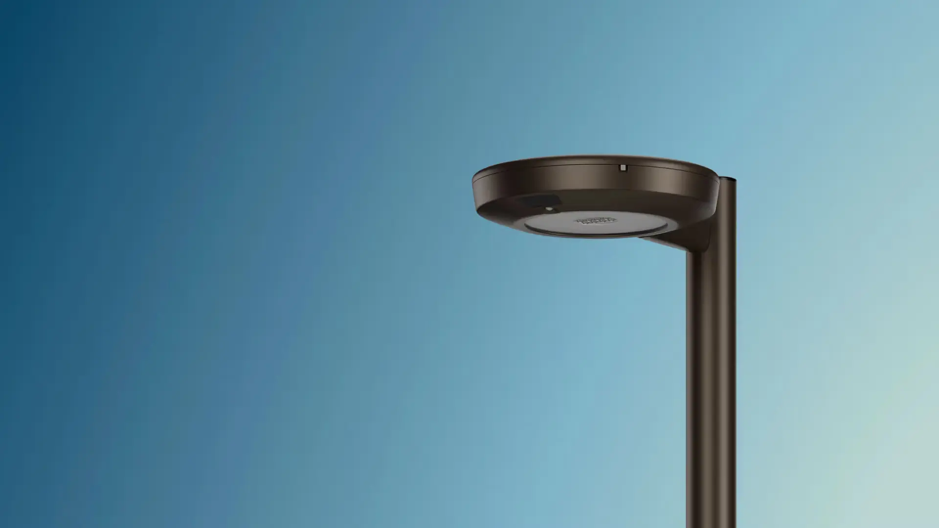 Modern black street lamp against a clear blue sky.