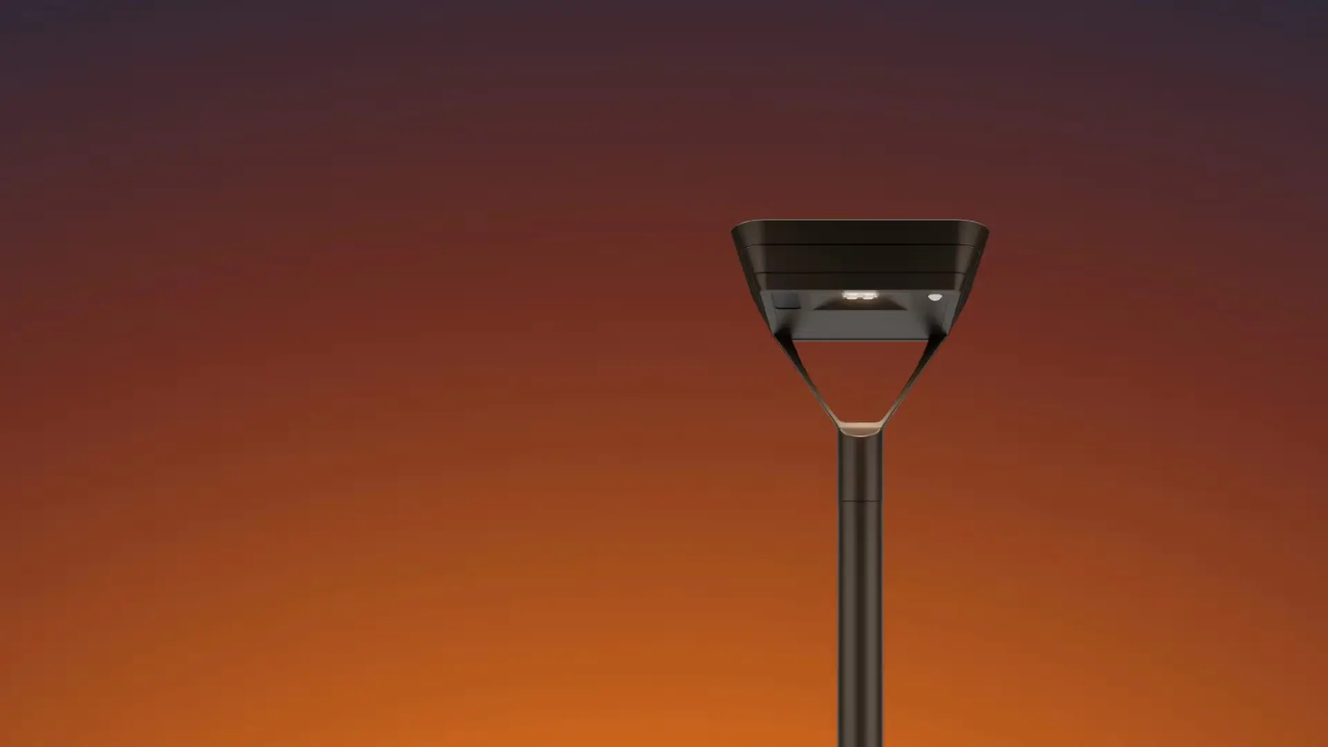 Modern black street lamp post against a gradient sunset sky.