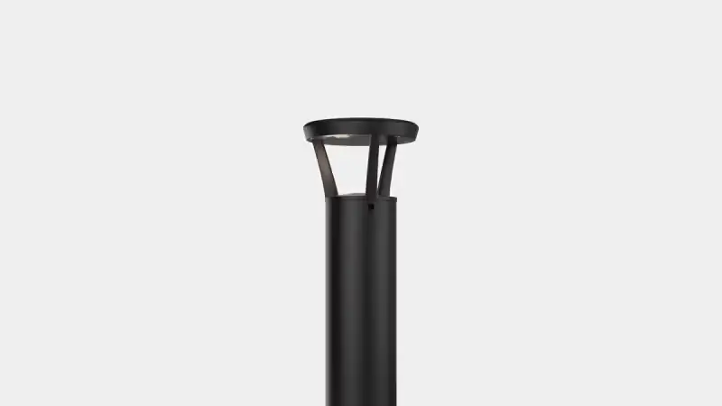 Tall black outdoor lamp post with a modern circular top against a plain light background.