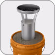 Metal bollard with a round black top secured inside a brown bucket.