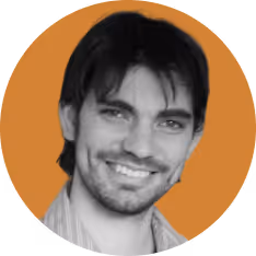Smiling man with dark hair and beard against an orange circular background.