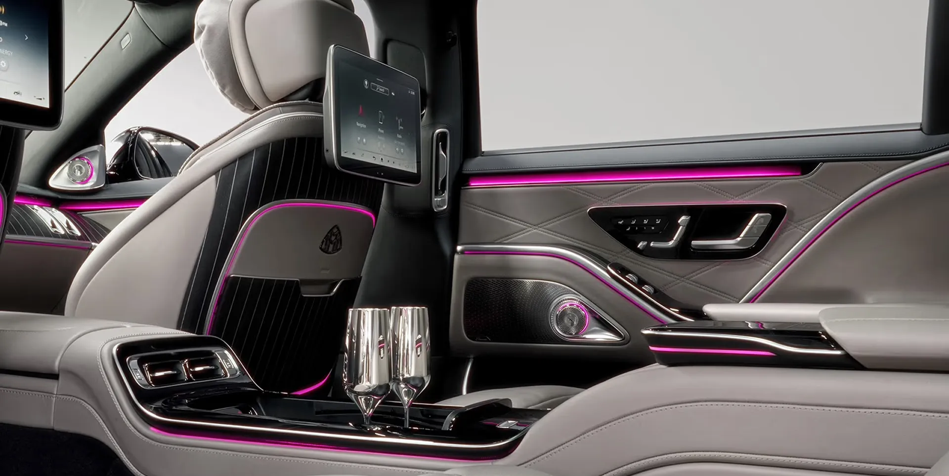 The rear cabin of a Mercedes-Maybach with glasses set in the console
