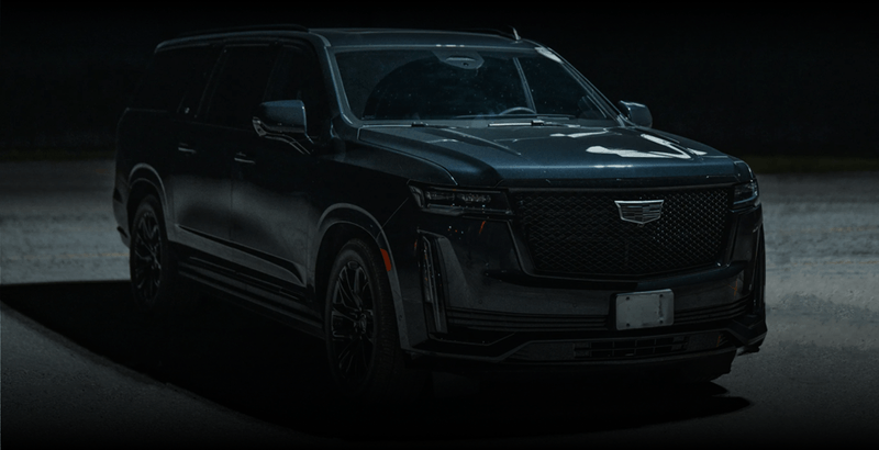 A black Cadillac Escalade parked at night