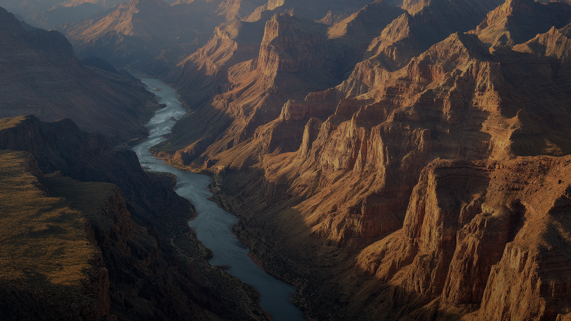 A river winding through towering rocky canyon cliffs lit by warm sunlight.