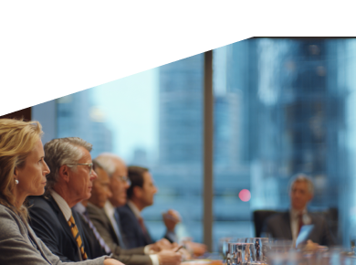 Group of business people in suits engaged in a meeting around a conference table with city view.