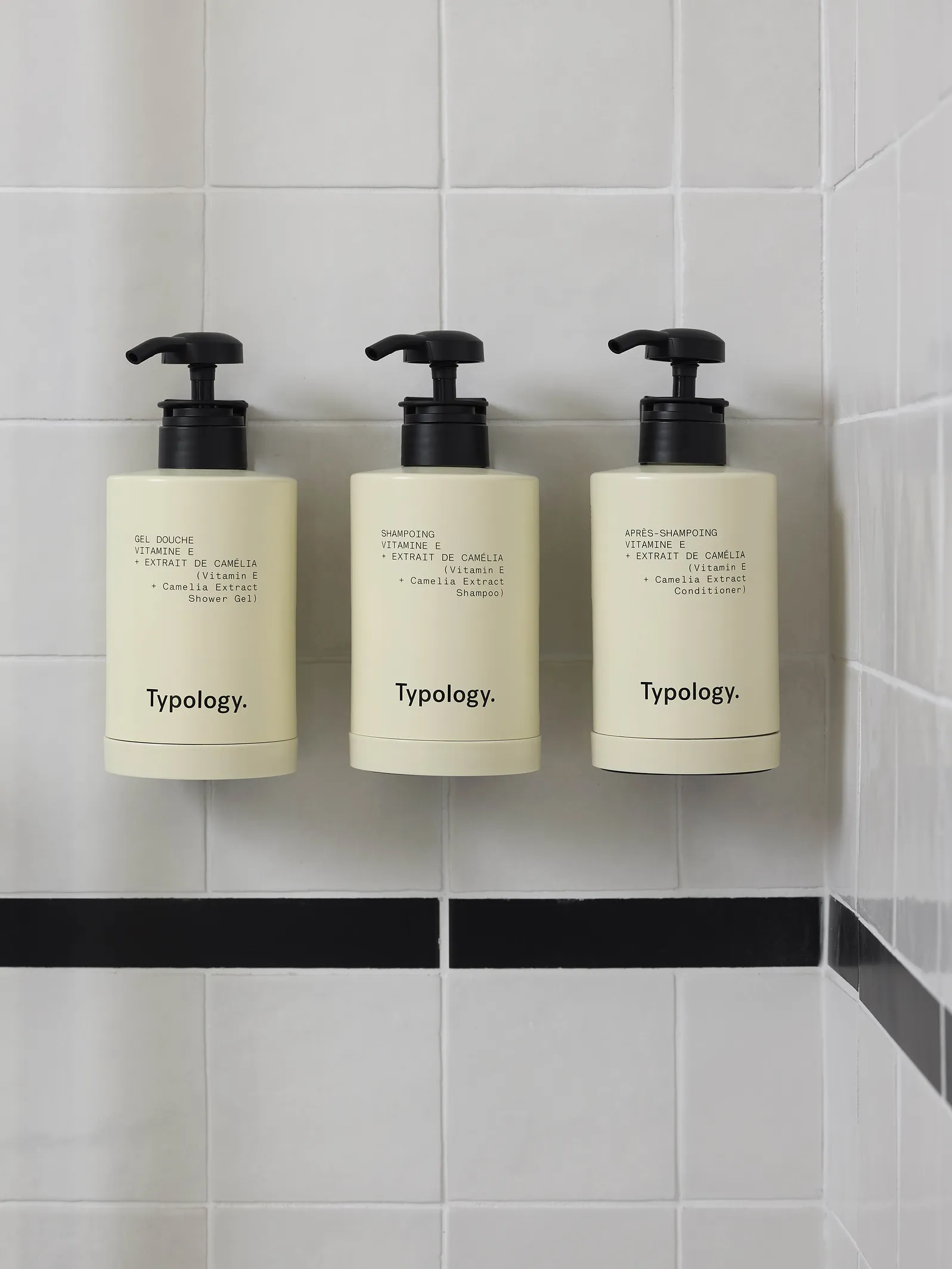 Trois flacons de produits de soin Typology sur étagère dans la salle de bain de l'hôtel Le Talaia Mgallery Biarritz