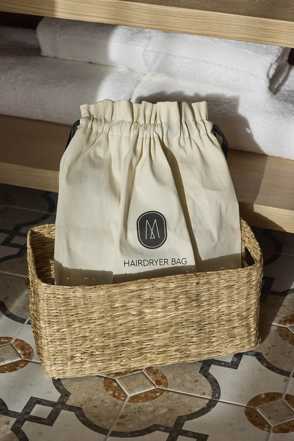 A linen pouch and a wicker basket in a room at the Le Talaia Mgallery Biarritz hotel
