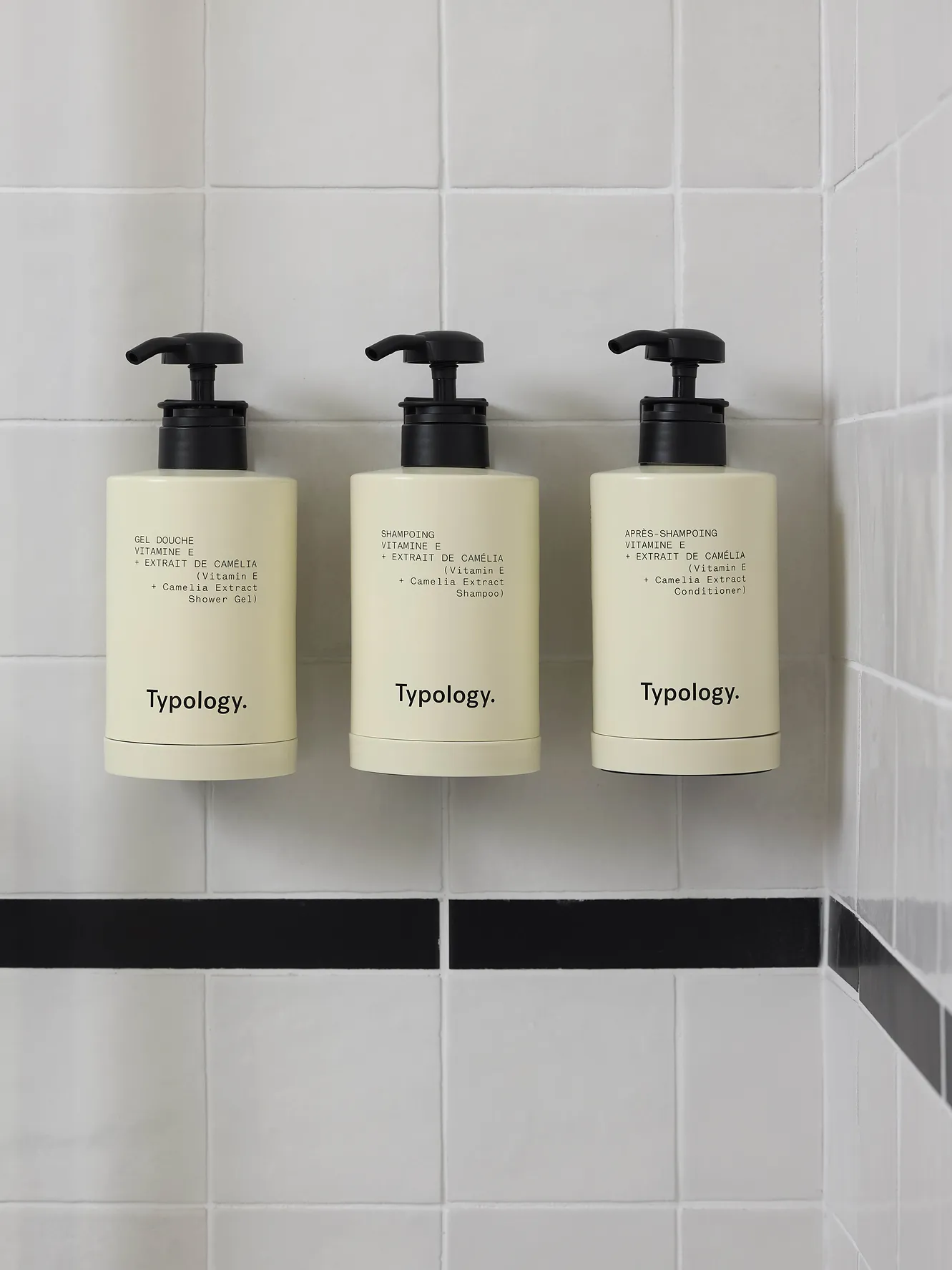 Trois flacons de produits de soin fixés au mur de la salle de bain de l'hôtel Le Talaia Mgallery Biarritz