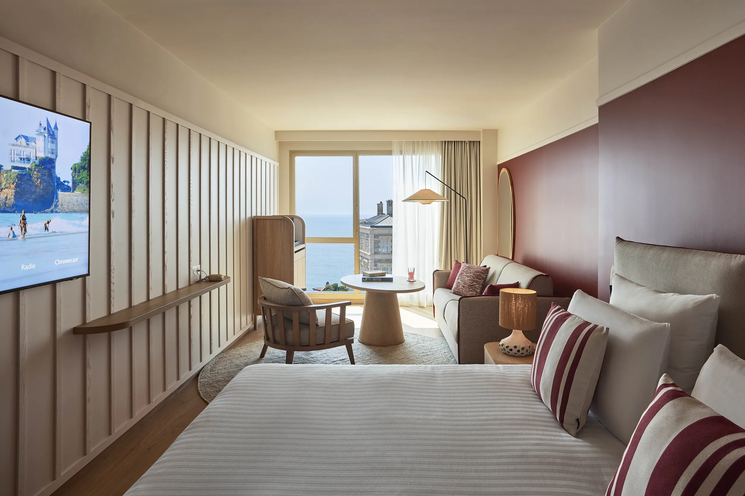 Chambre avec vue océan de l'hôtel Le Talaia Mgallery Biarritz avec lit king-size, télévision murale et coin salon lumineux