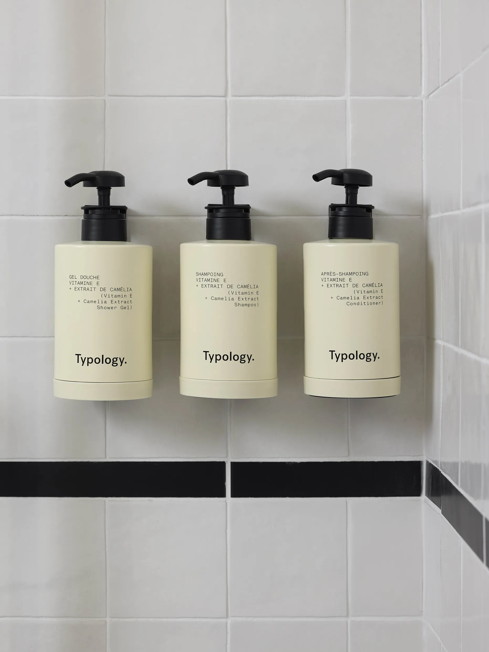 Trois flacons de produits de soin Typology alignés dans la salle de bain de l'hôtel Le Talaia Mgallery Biarritz