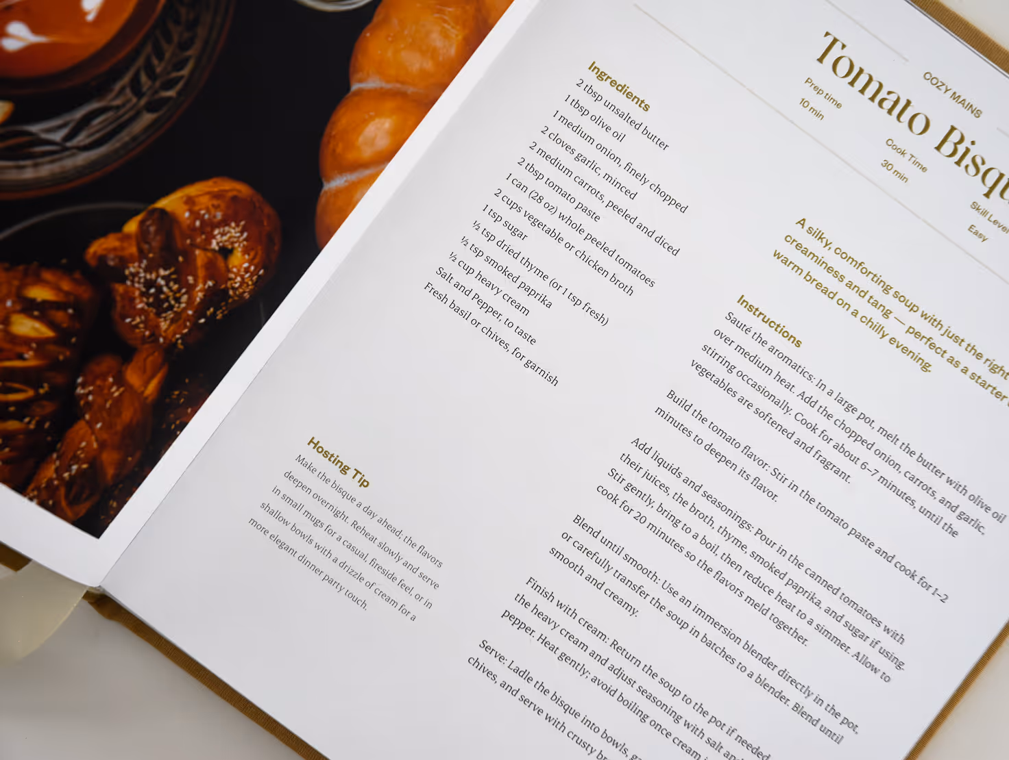 Open cookbook showing ingredients and instructions for preparing tomato bisque soup. Credit: May-Lee Abel