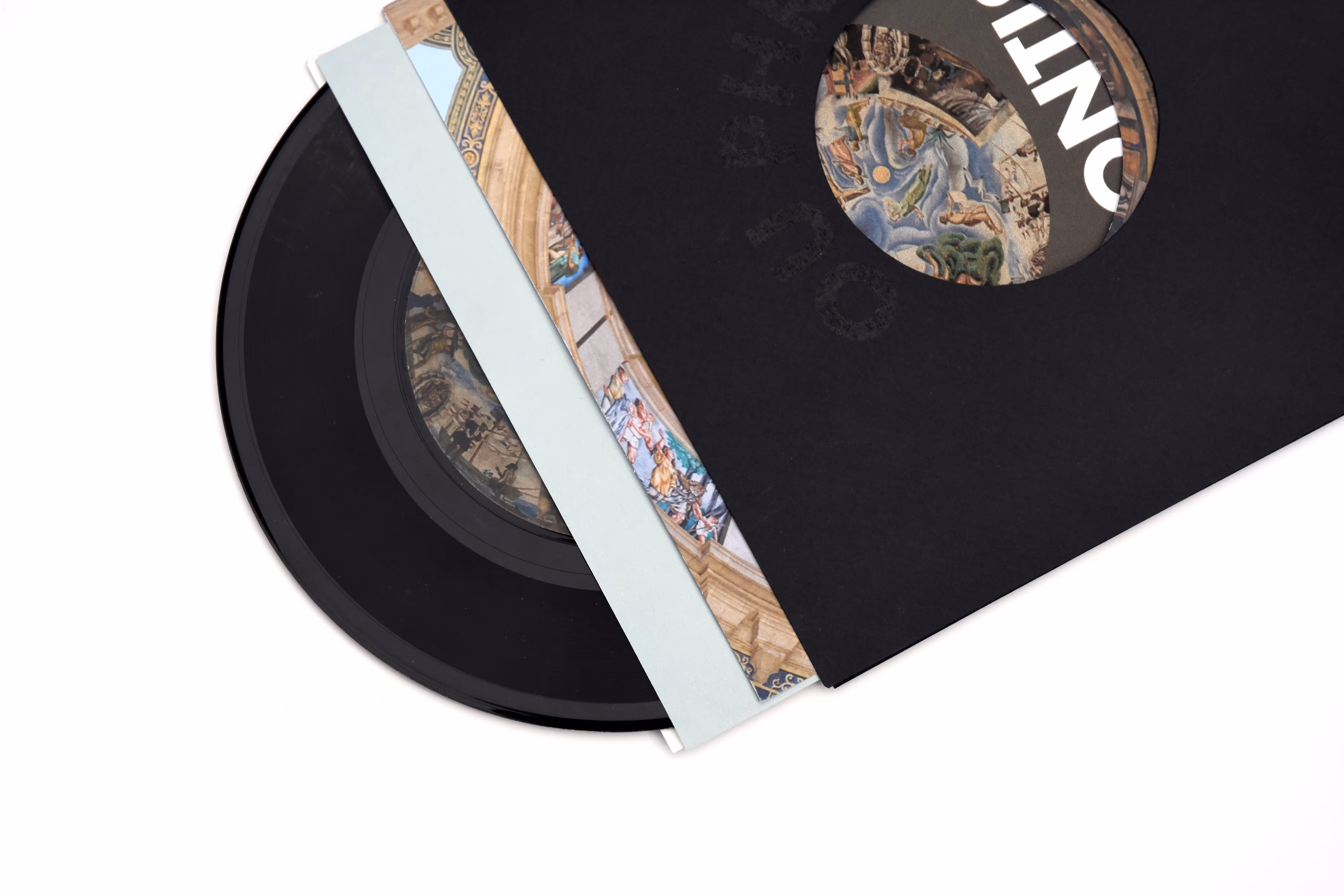 Black vinyl record partially inside a black sleeve with a circular cutout showing artwork underneath. Credit: May-Lee Abel