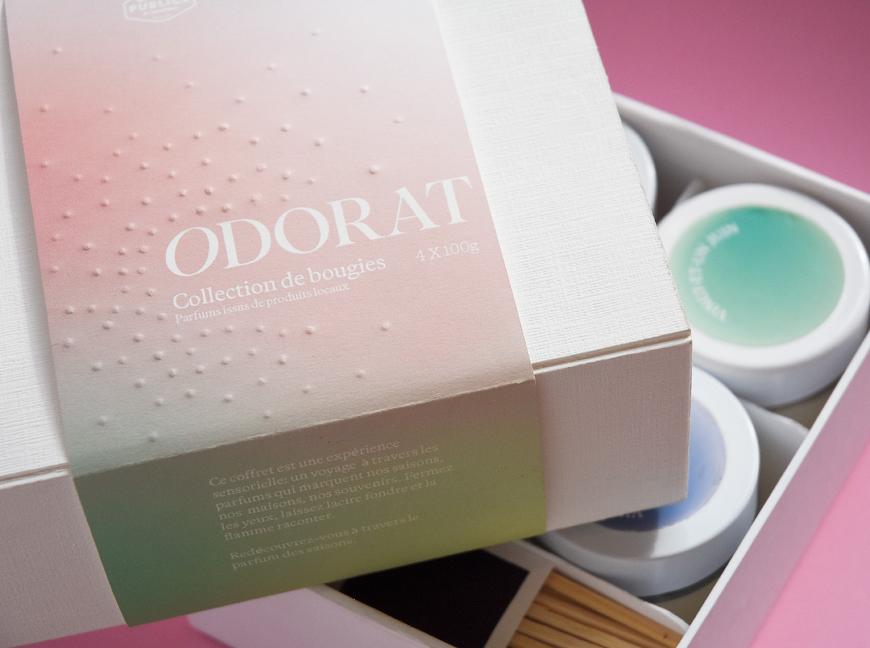 Box set of four colorful scented candles with a pastel gradient cover labeled Odorat Collection de bougies. Credit: May-lee Abel