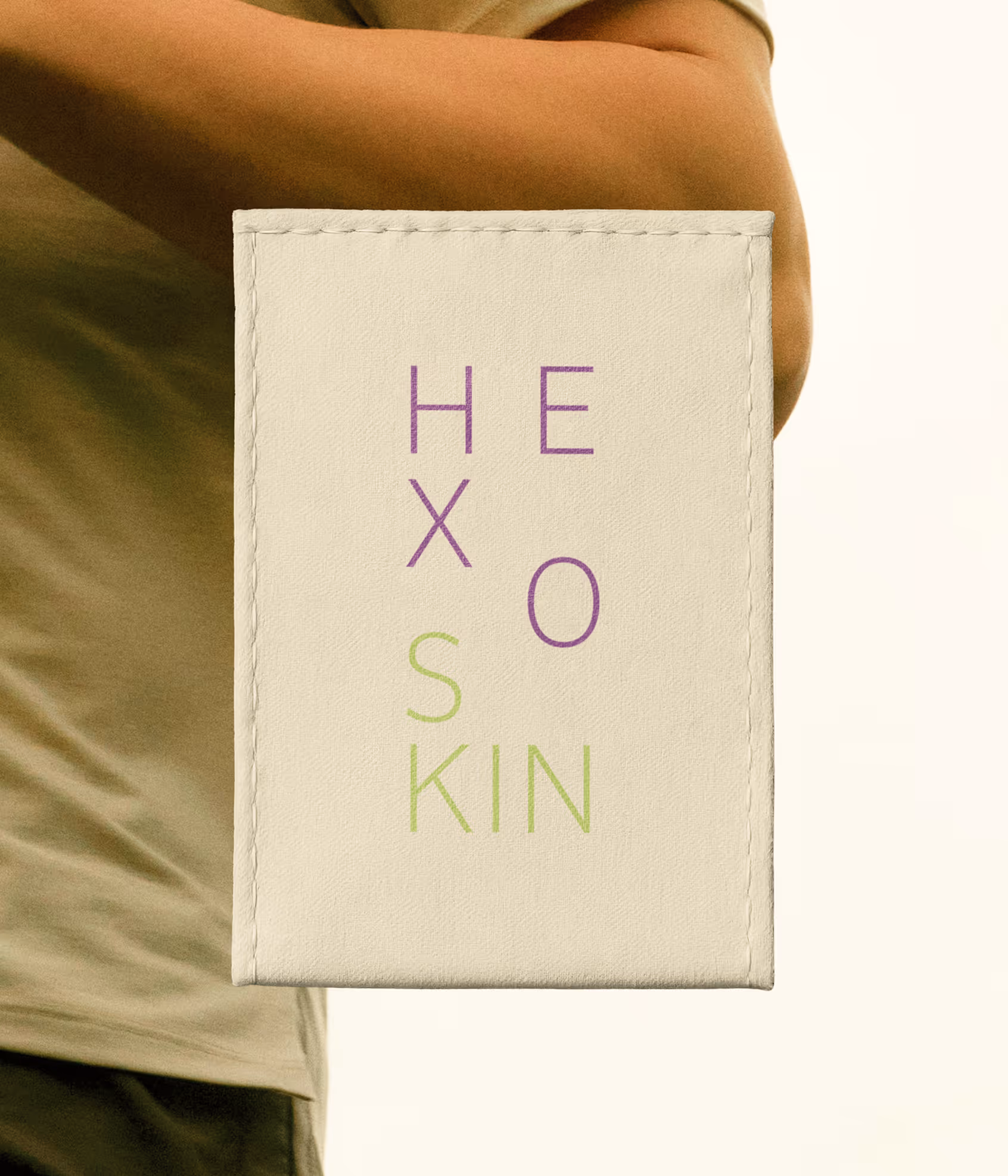 Person holding a beige wallet with HEXOSKIN written in purple and green letters. Credit: Death to stock and May-lee Abel
