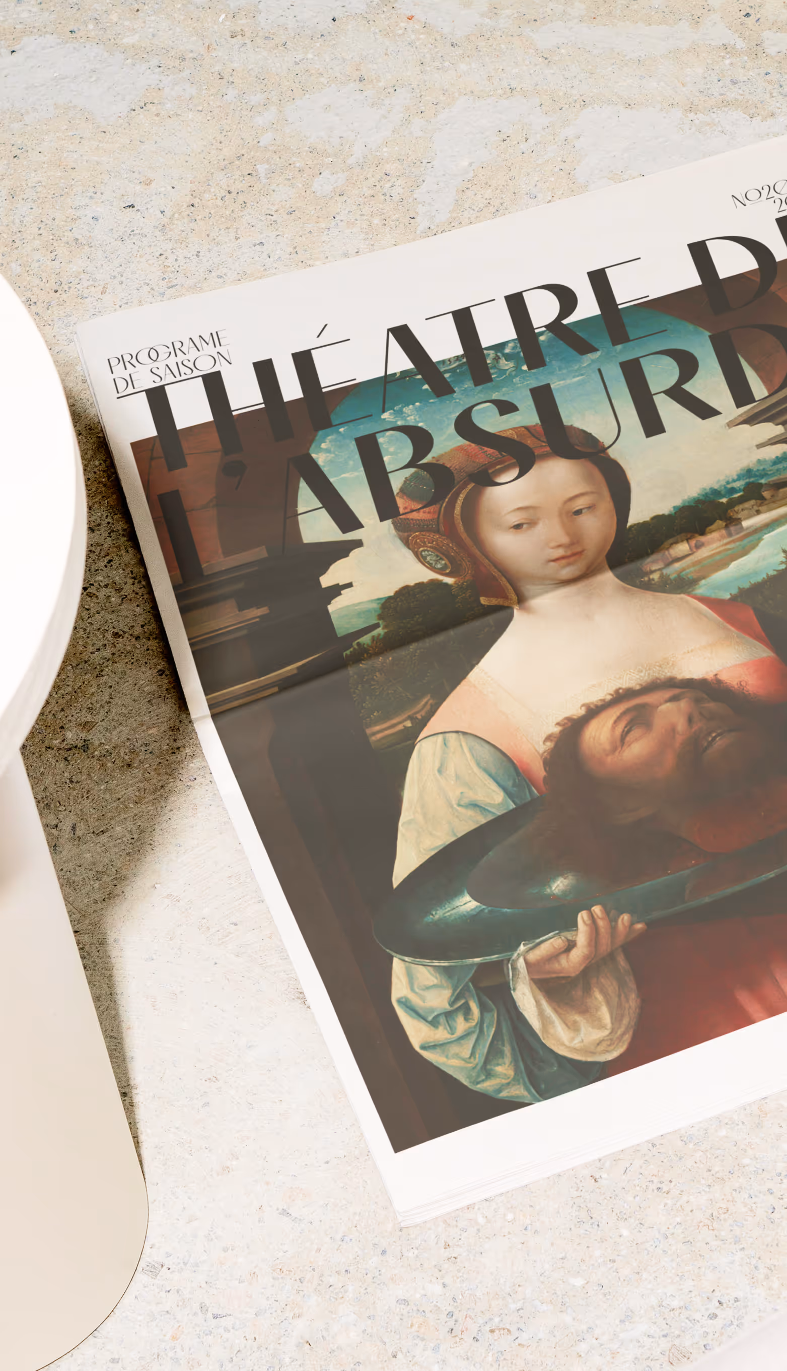 newspaper cover titled Théâtre de l'Absurde with a painting of a woman holding a platter with a man's head. Credit: Bendito mockup
