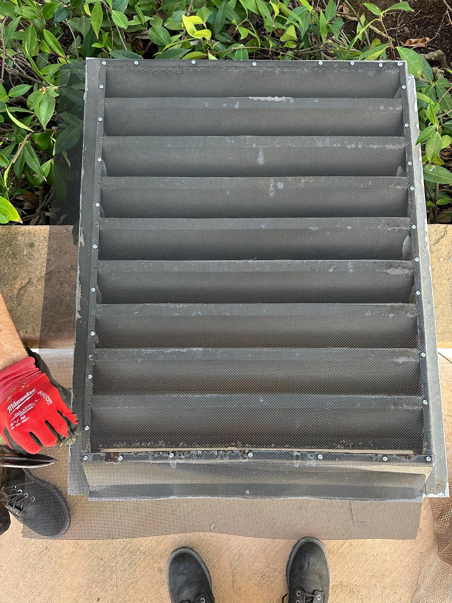 Wildfire Warden technician installing ember-resistant mesh screen over a vent cover — professional wildfire home hardening service