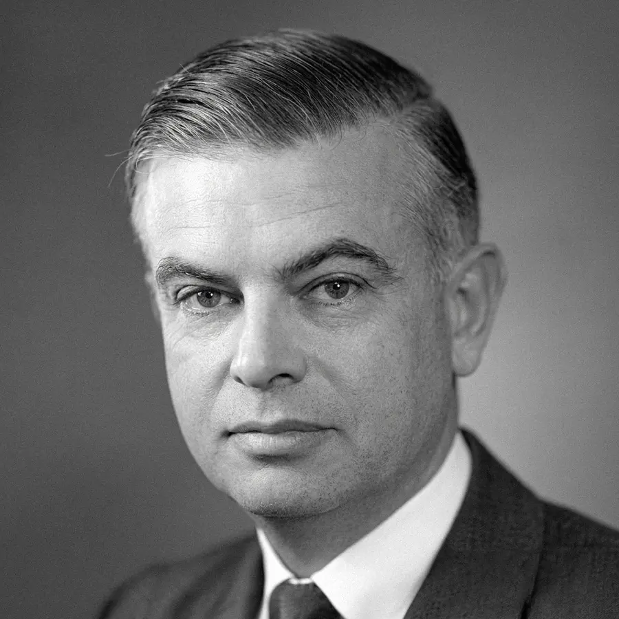 Black and white portrait of a middle-aged man in a suit and tie with neatly combed hair.