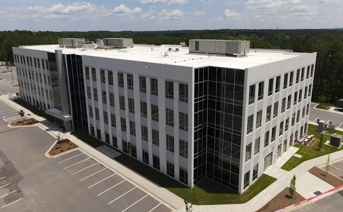 Aerial drone view of the completed Innovation Quarter office building in North Carolina featuring multi-story glass curtain wall and punched window systems installed by BrightLeaf Glass and Metal