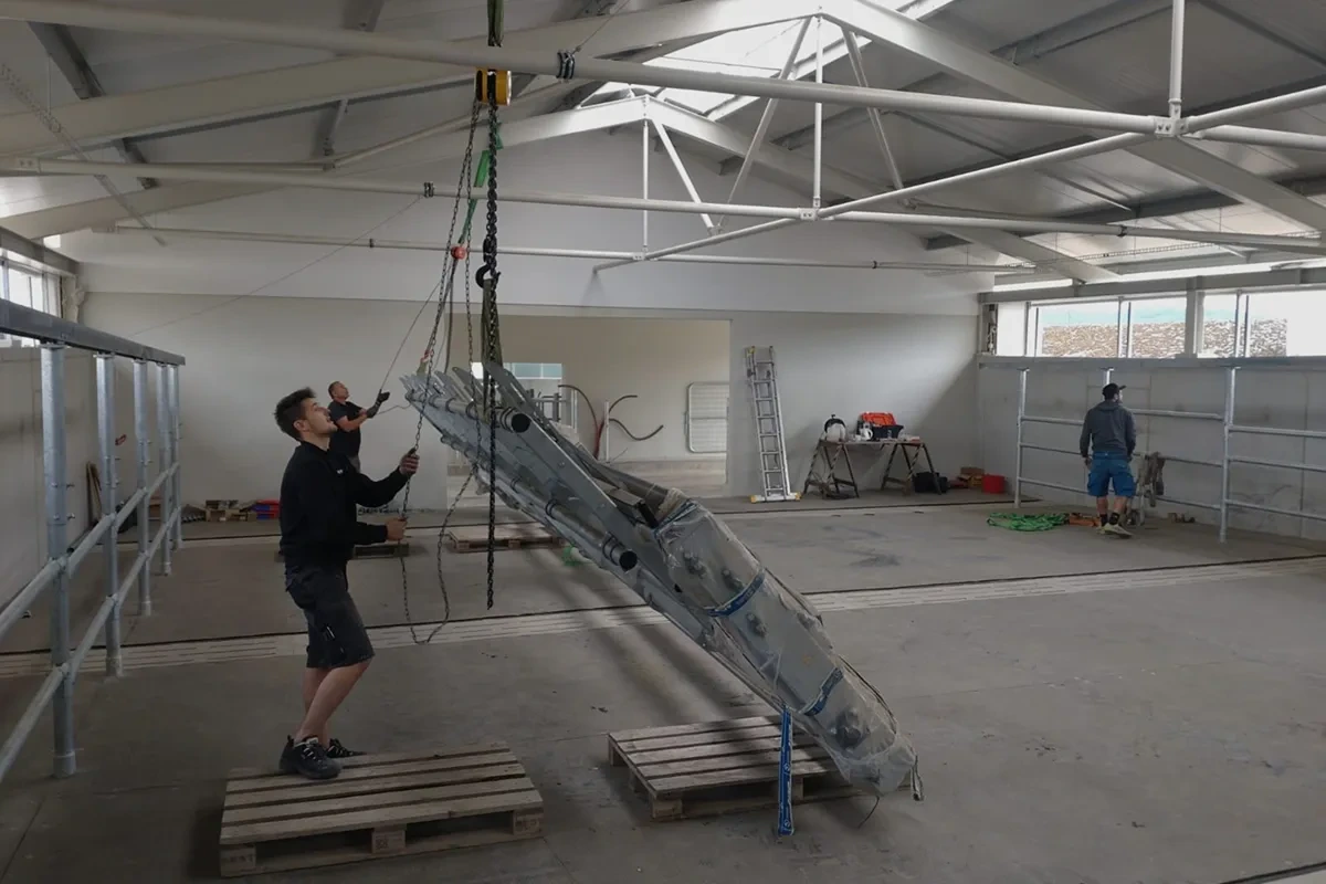 Montážník zvedá konstrukci technologie v rozestavěné hale