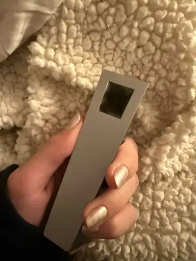 Silver Mercury Tempest pipe held in hand with packed bowl against textured blanket
