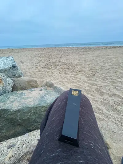 Black Abyss Tempest pipe resting on leg at rocky beach with ocean in background
