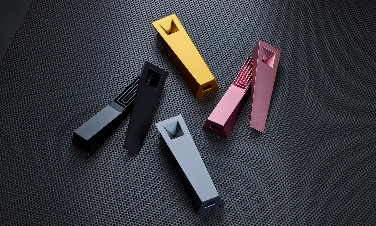 Tempest magnetic cooling pipe collection in black Abyss, gold Radiance, silver Mercury, and pink Glimmer on textured metal surface showing assembled and open configurations