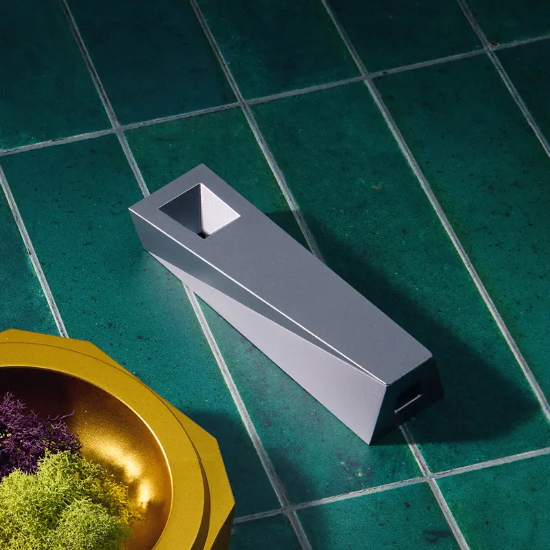 Silver Tempest magnetic cooling pipe on glossy emerald-green tile surface with gold bowl accessory