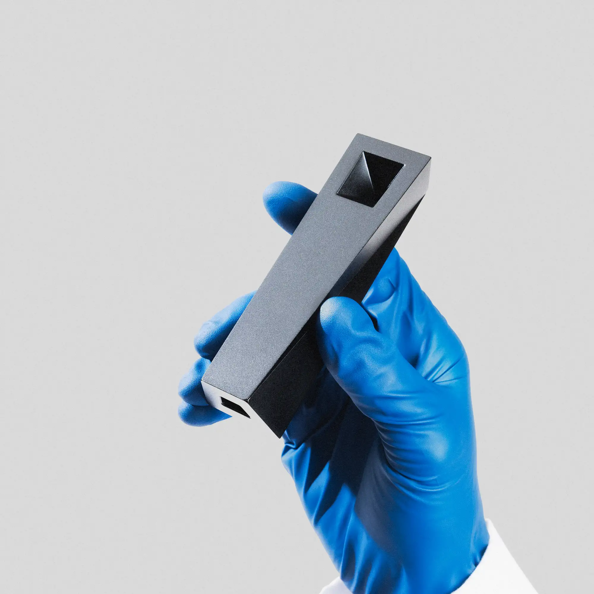 Tempest pipe held in gloved hand showcasing minimalist form and precision-machined aluminum body