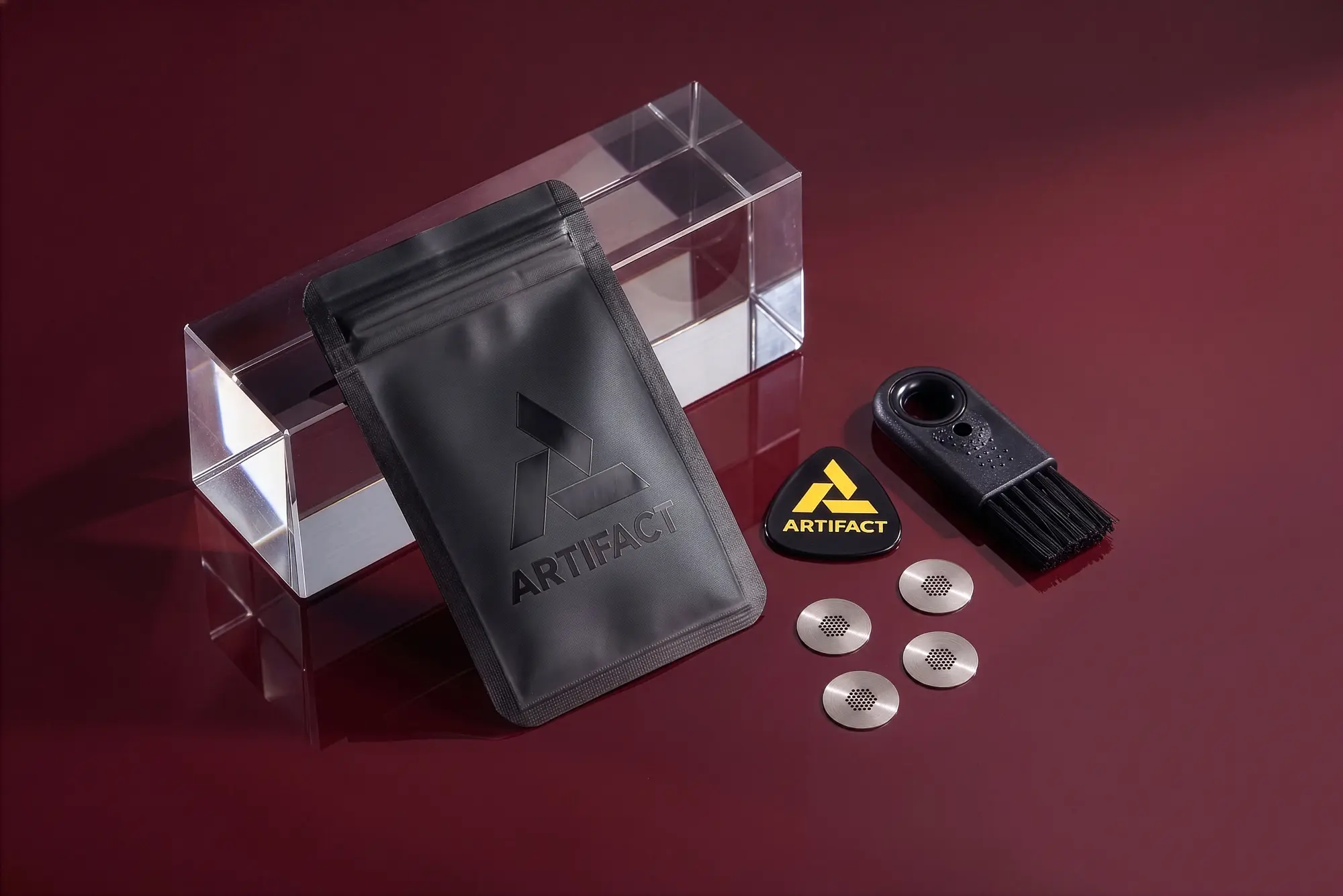 Tempest Field Kit contents on a red surface: black pouch with Artifact logo, cleaning brush, bowl pick, and four titanium screens
