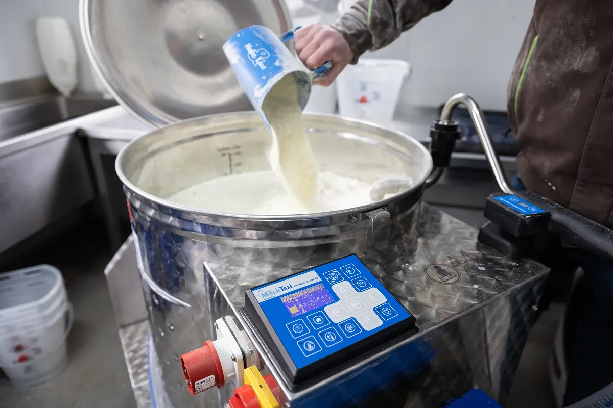Sypání mléčné krmné směsi do nádoby vozíku MilkTaxi