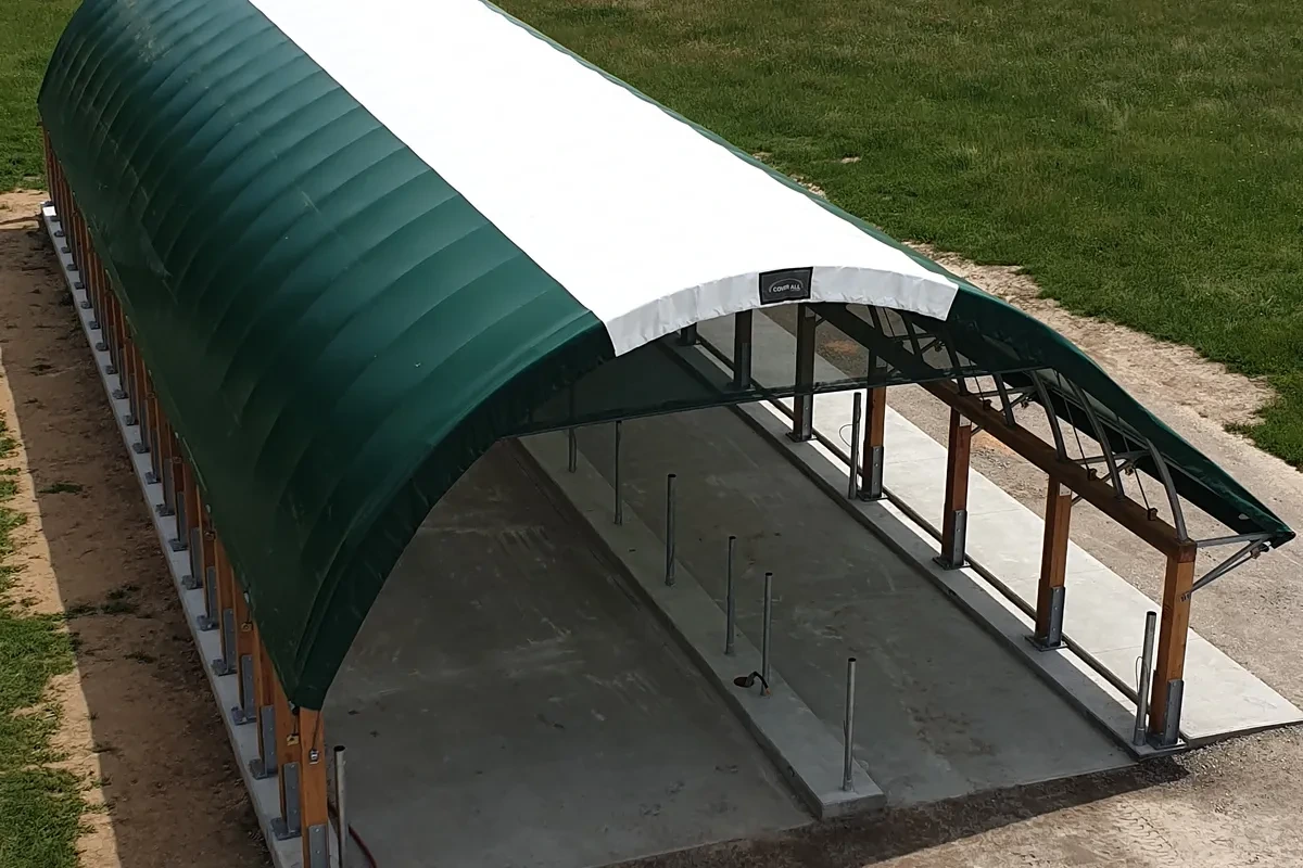 Vnitřek plachtové haly s dřevěnou konstrukcí a betonovou podlahou