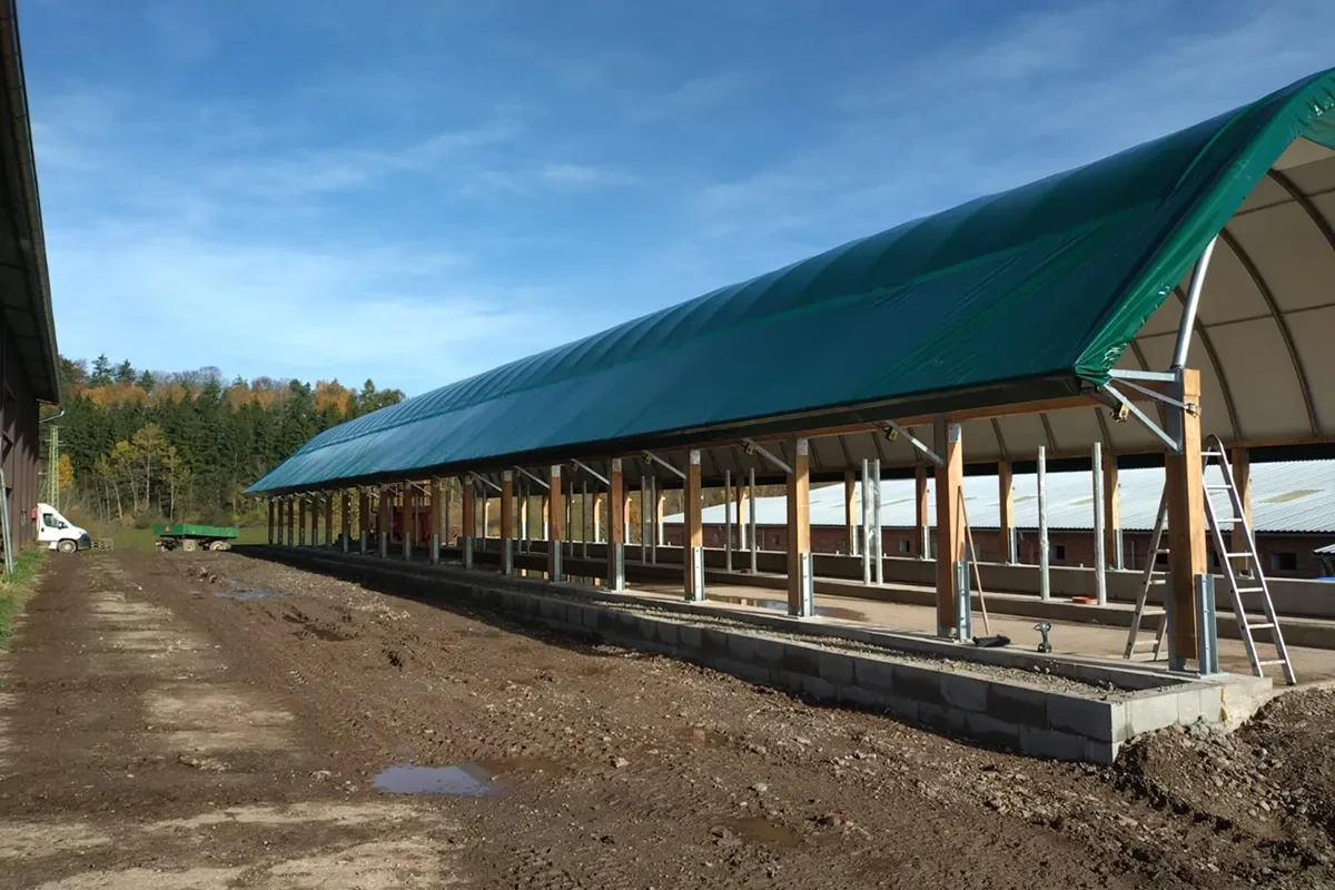 Plachtová hala během dokončování s betonovou podlahou a žebříkem