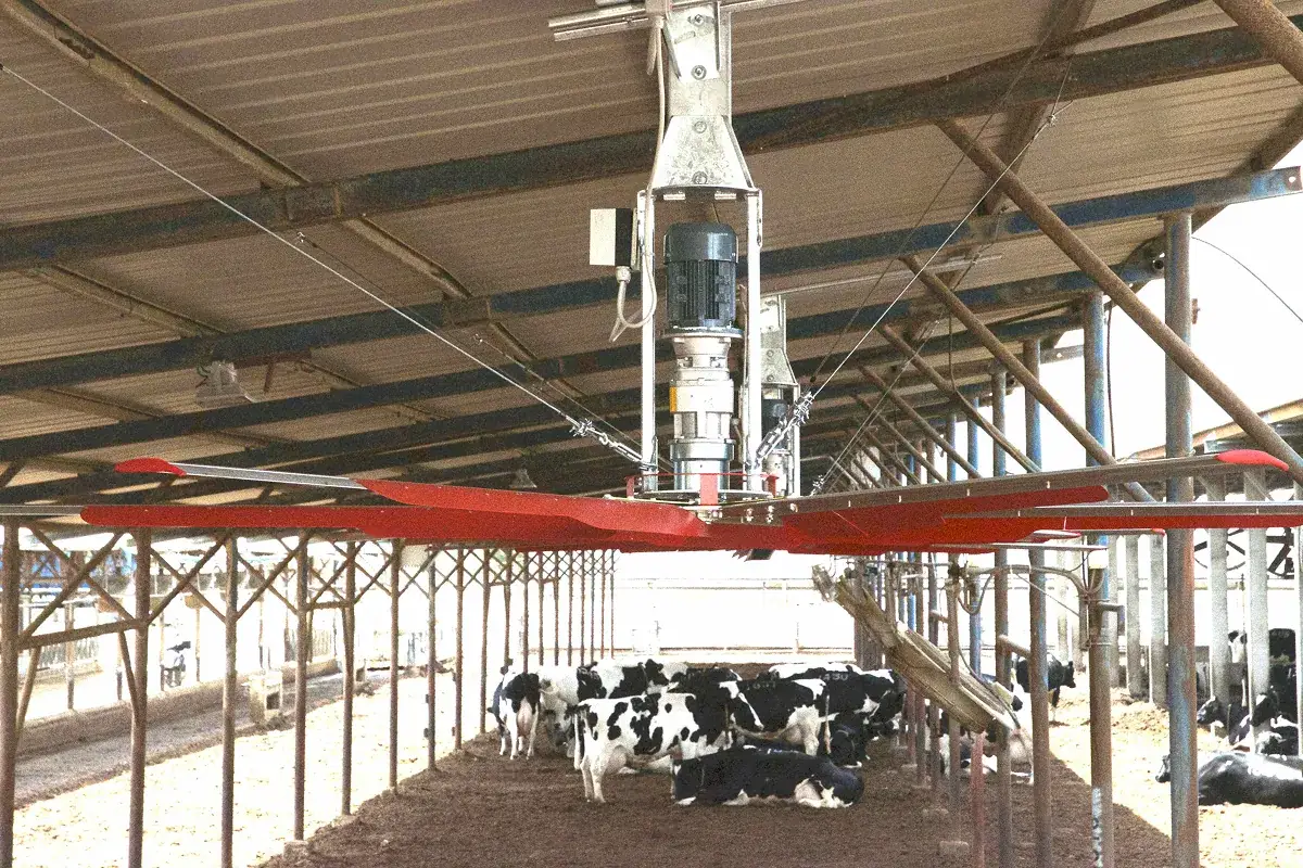 Pohonná jednotka stropního ventilátoru zavěšená pod střechou stáje