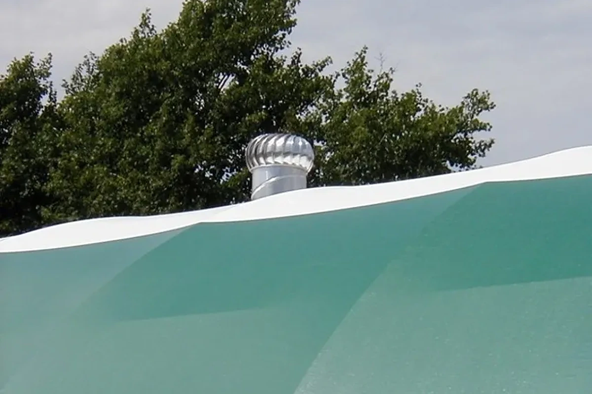 Ventilační turbína na hřebeni zelené plachtové střechy