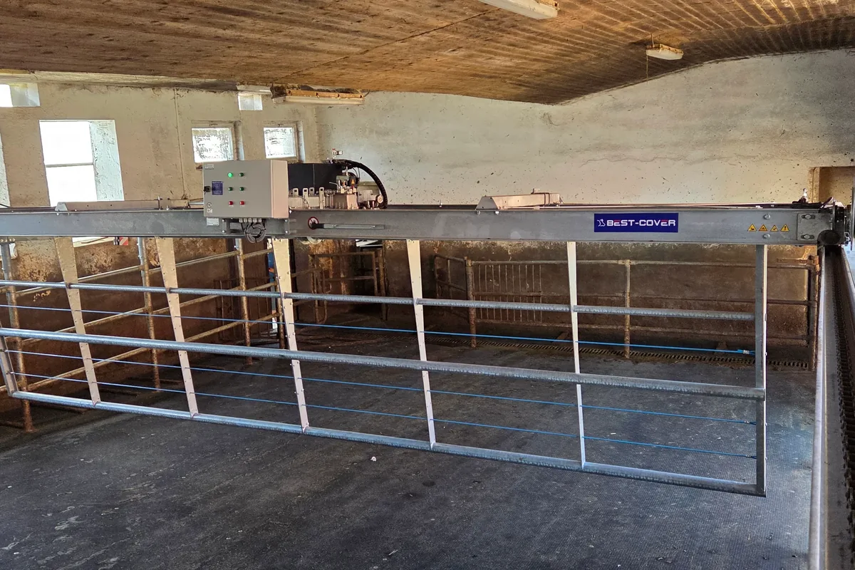 Automatický přiháněč pod klenutým stropem starší zděné stáje