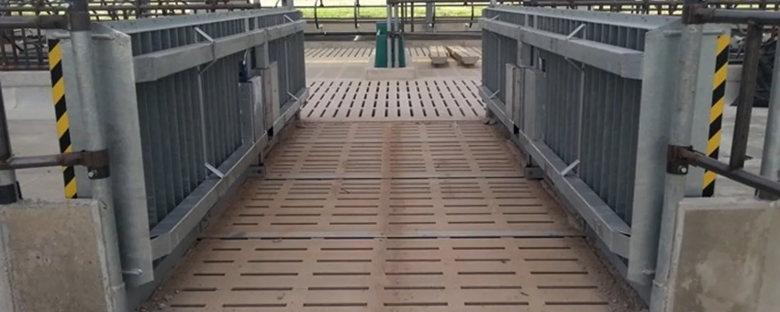 Hydraulická brána sklopená do roviny krmného stolu s výstražným značením