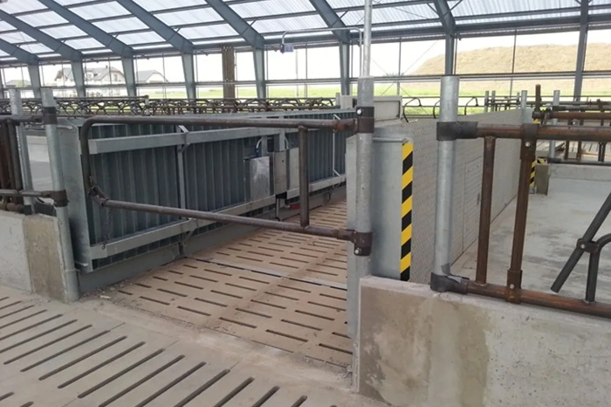 Hydraulická brána přes krmný stůl v nové stáji s roštovou podlahou