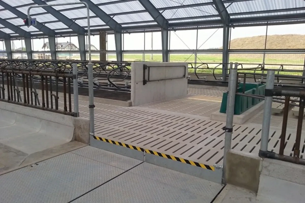 Hydraulická brána sklopená v rovině krmného stolu s výstražným značením