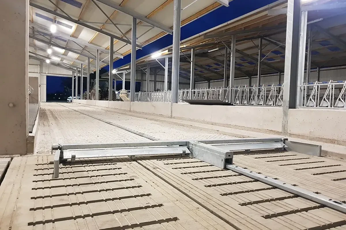 Shrnovací lopata na roštové chodbě nové stáje